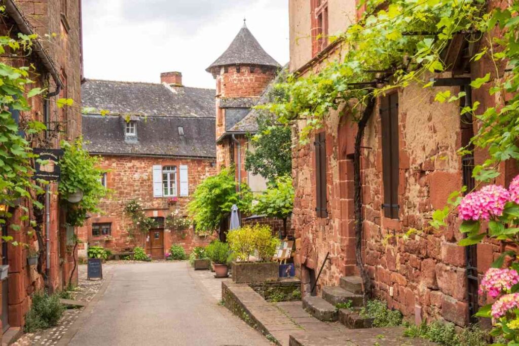 Red houses and green plants seen from the street in Collonges-la-Rouge
