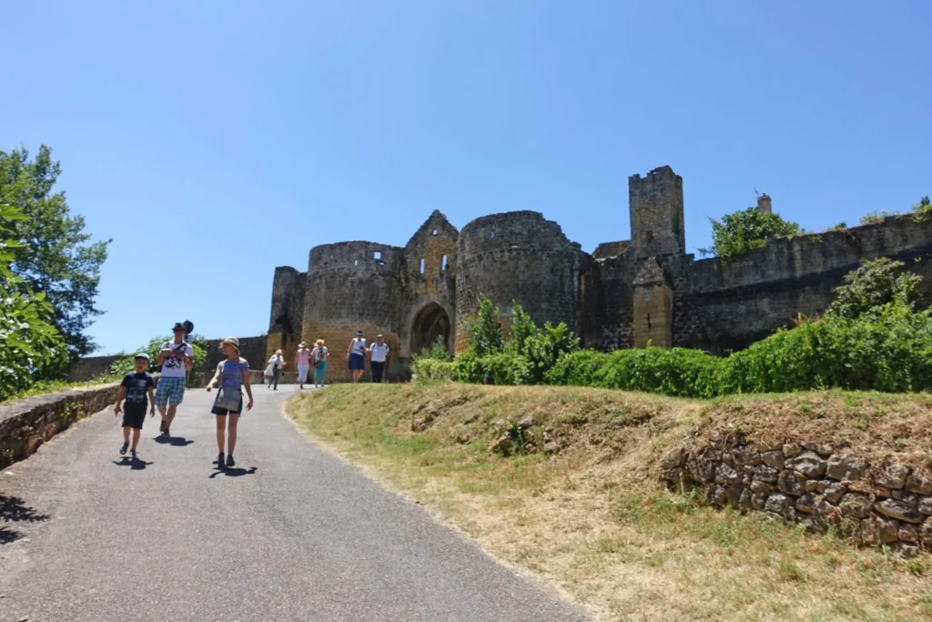 Tourists walking toward Porte des Tours medieval gate in Domme, Dordogne