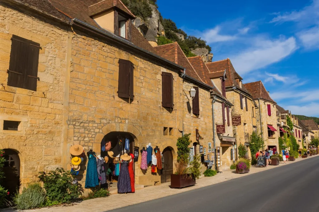 Honey-coloured stone houses and boutique shops in La Roque Gageac village, Périgord Noir, Dordogne