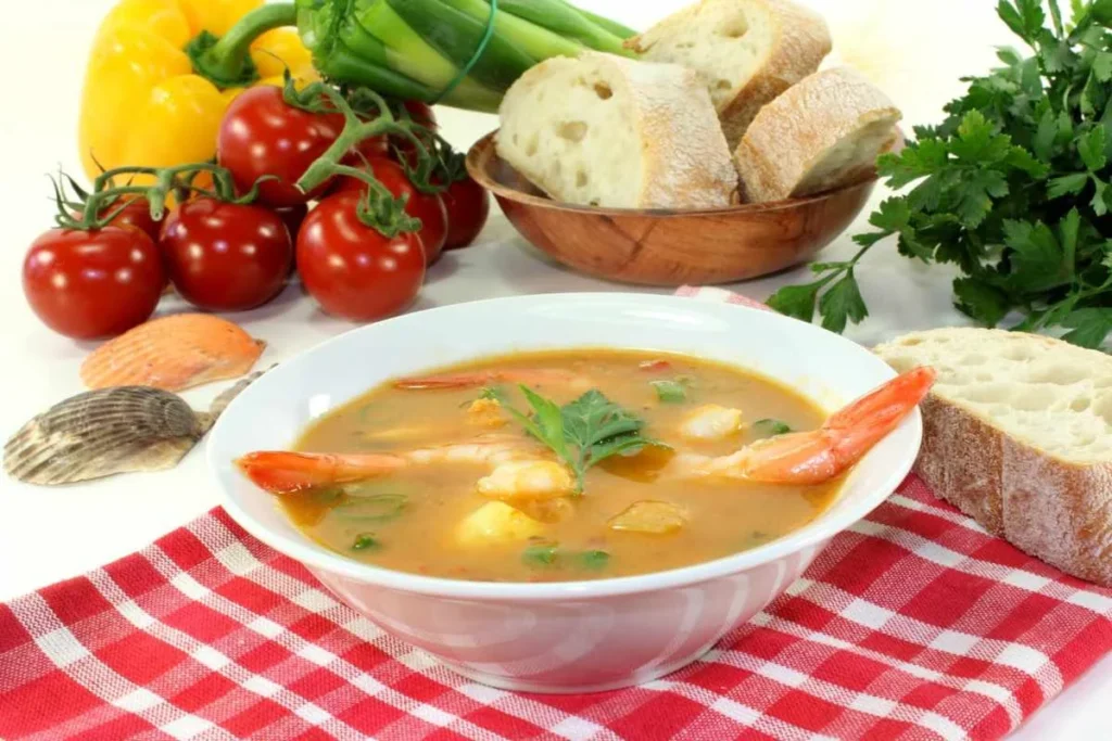 Traditional French seafood soup served with bread and fresh vegetables