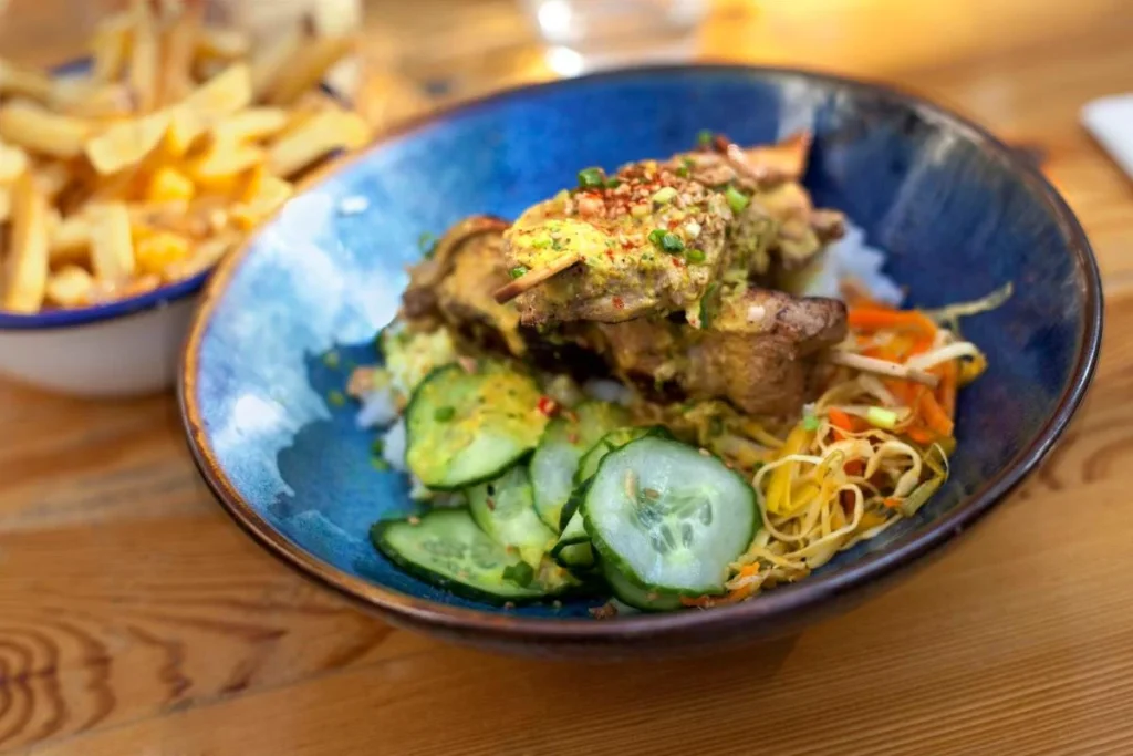 French bistro-style meal with fries, cucumber salad, and plated main dish