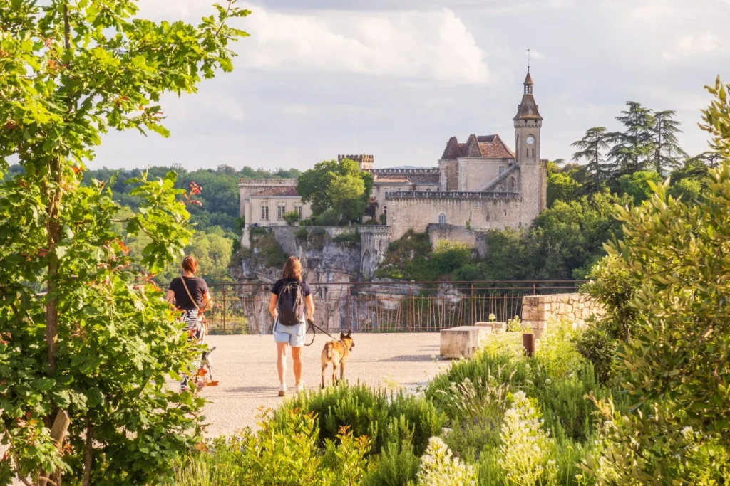 Visitors walking toward a viewpoint with Rocamadour castle and sanctuary across the valley