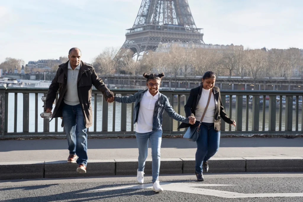 Family walking near Eiffel Tower along Seine River