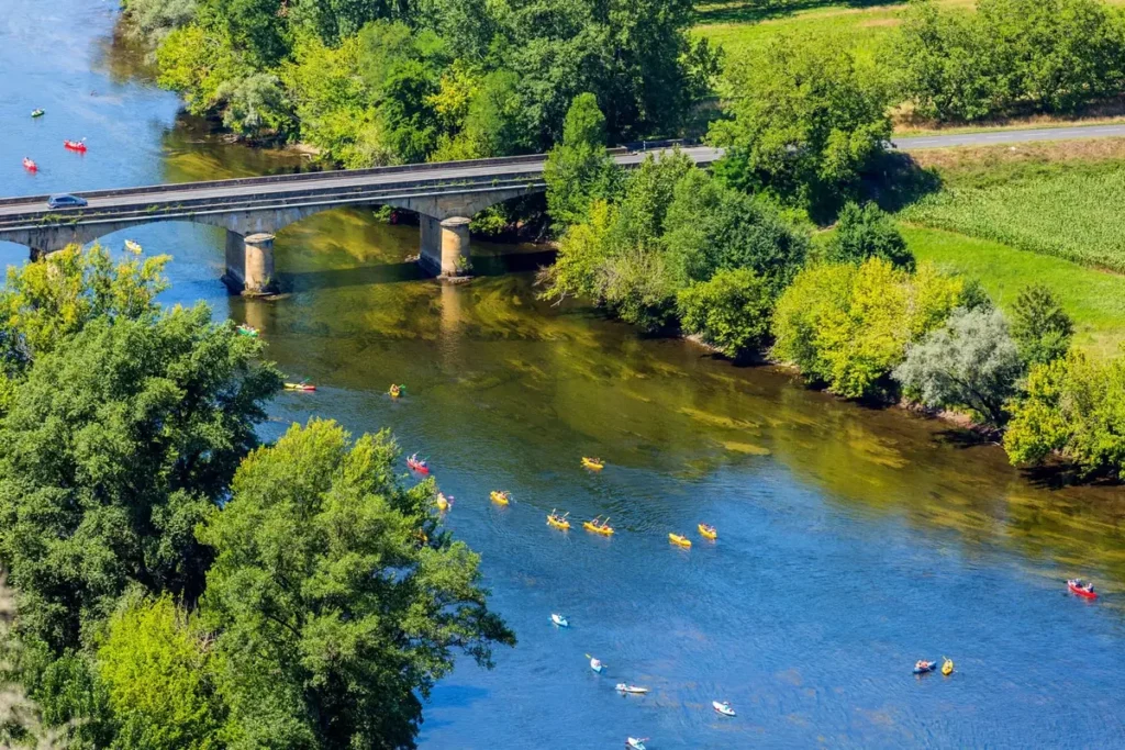 Bridge over the Dordogne River with kayaks on the water