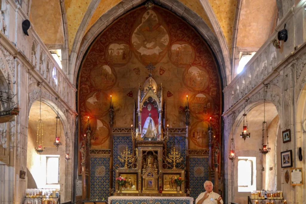 Ornate interior of a Rocamadour chapel with altar, religious artwork, and warm lighting