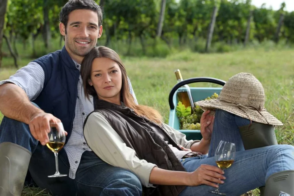 Couple enjoying wine in a French vineyard picnic setting
