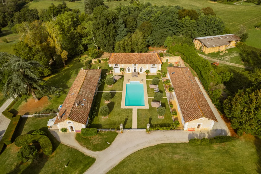 Aerial view of French château estate with pool, gardens, and surrounding countryside