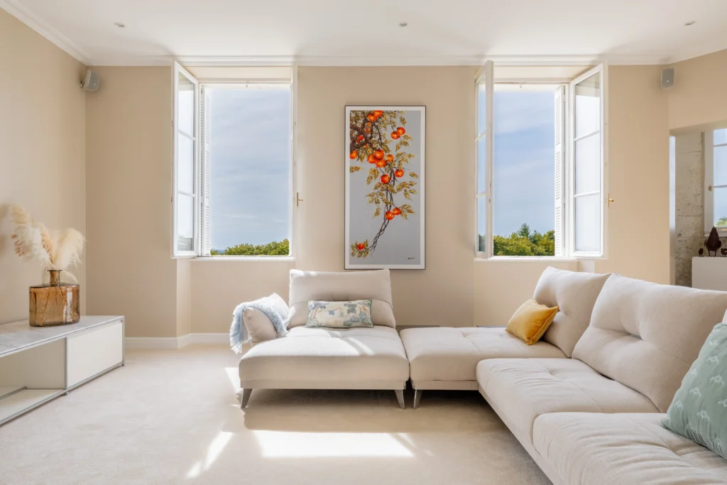 Stylish chateau in france to stay: living room with teal wall, artwork, and modern seating