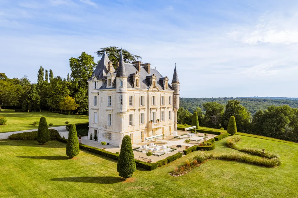 Elegant French château with manicured gardens and surrounding countryside views in Dordogne region