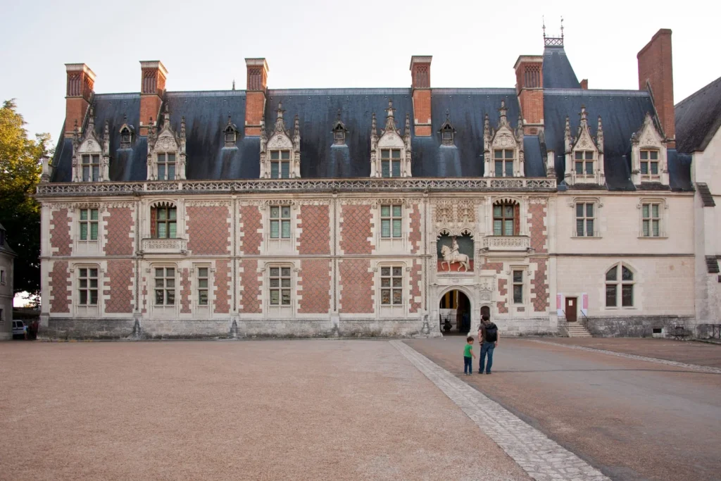 Tourists near the ornate entrance of Château de Blois in France
