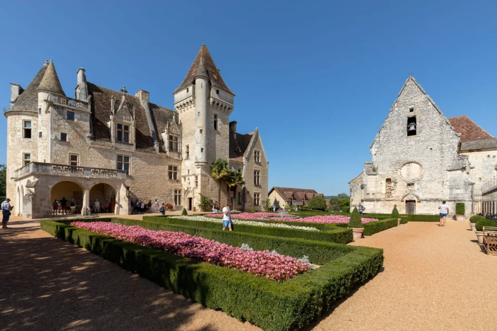 Château des Milandes with formal gardens, flower beds, and chapel courtyard in Dordogne, France