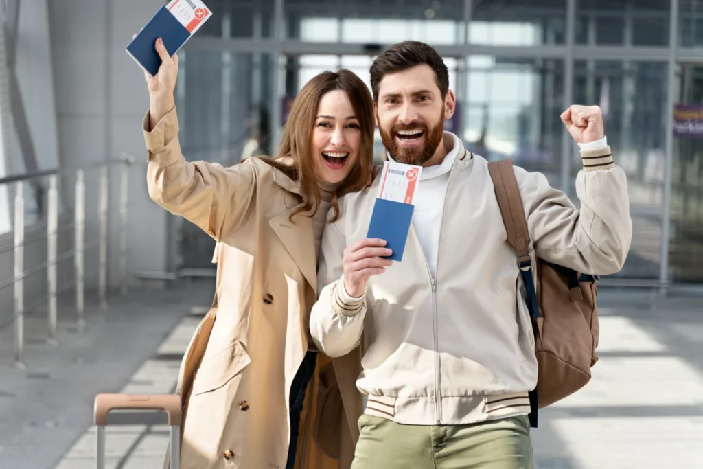Happy travelers holding passports and boarding passes after approval for France travel or visa journey