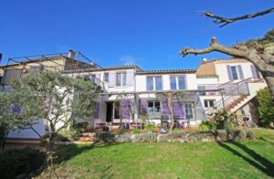 Traditional villa with a garden, terrace, and bright blue sky