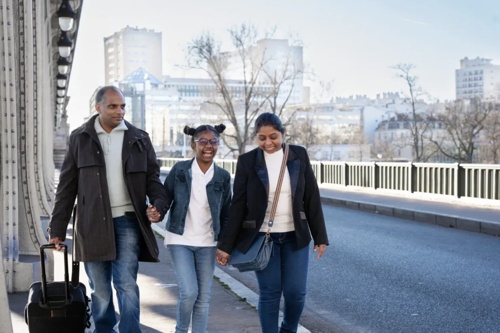 Family walking with luggage in a French city