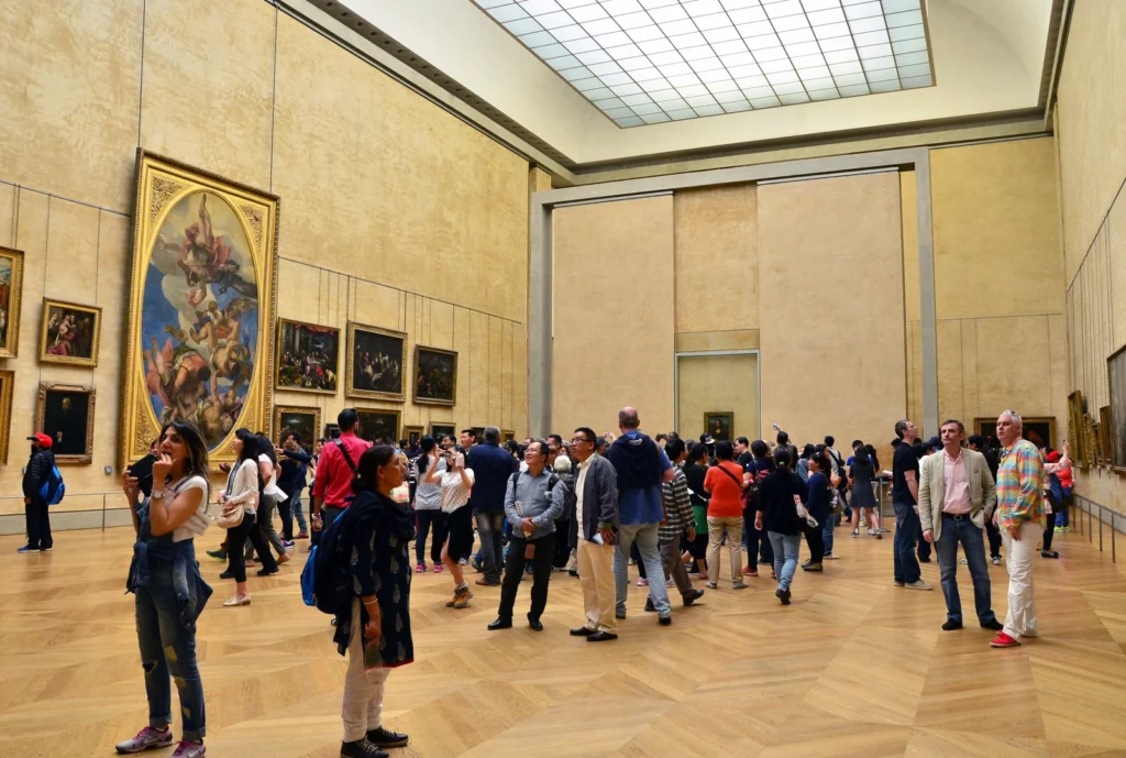 Visitors viewing artwork inside the Louvre Museum