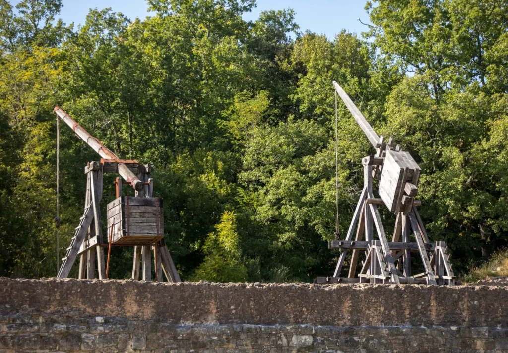 Reconstructed medieval trebuchets used for siege warfare at a castle site.