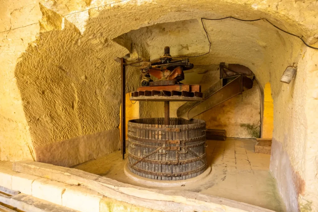 Old wine press inside a stone cellar