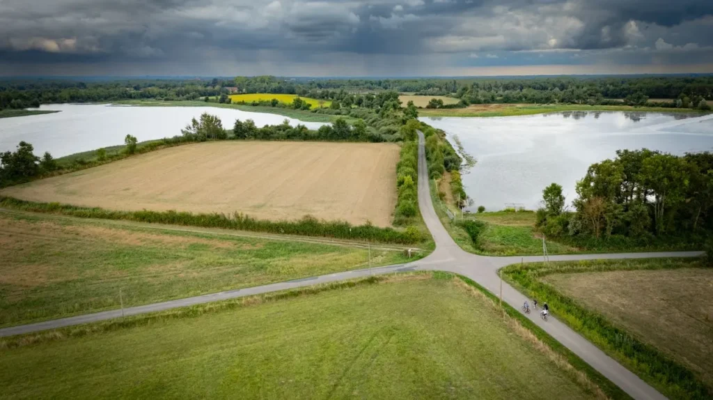 Rural road between lakes and farmland in France
