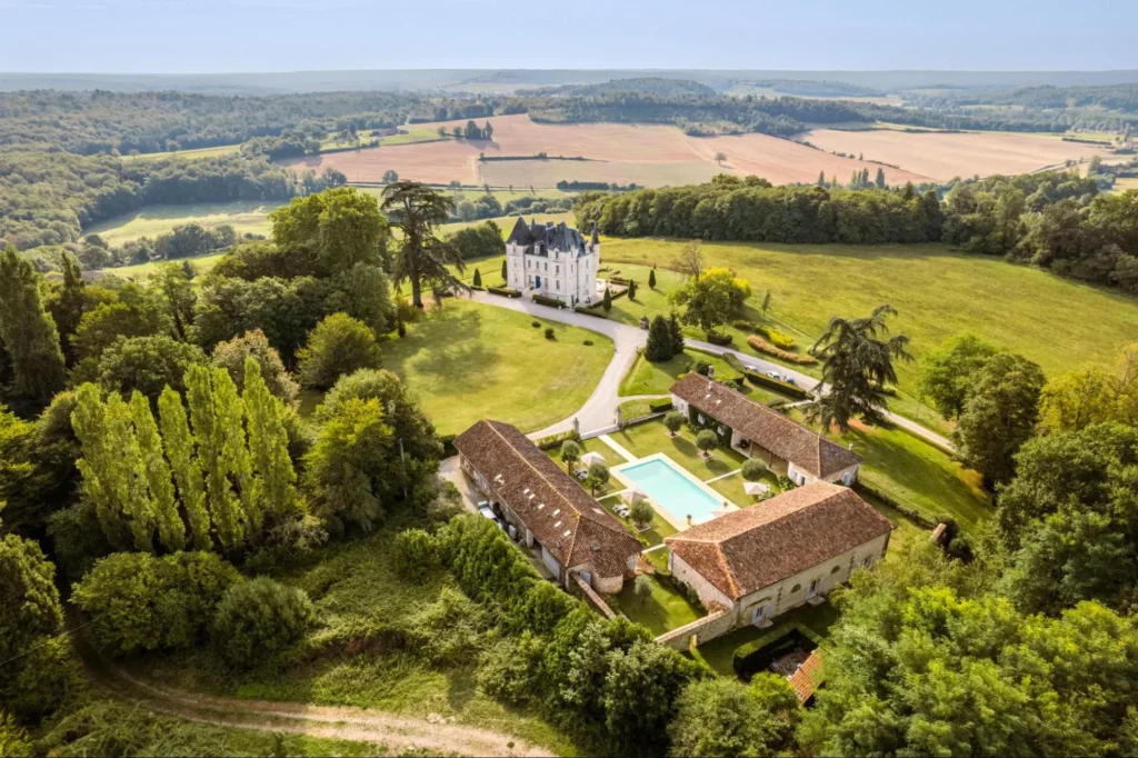 Aerial view of a private French chateau estate with pool, gardens, and countryside views