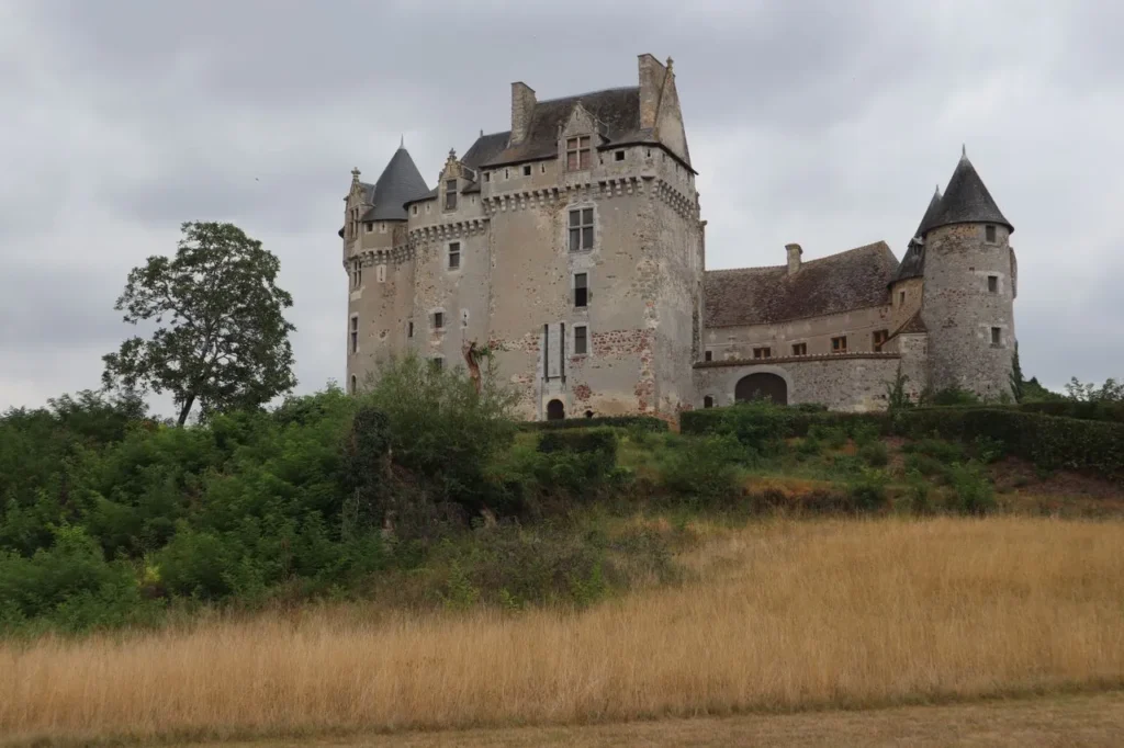 Abandoned French chateau on a hill under cloudy sky
