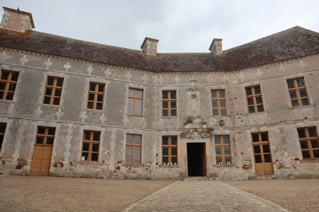 Weathered chateau courtyard with old stone walls and windows