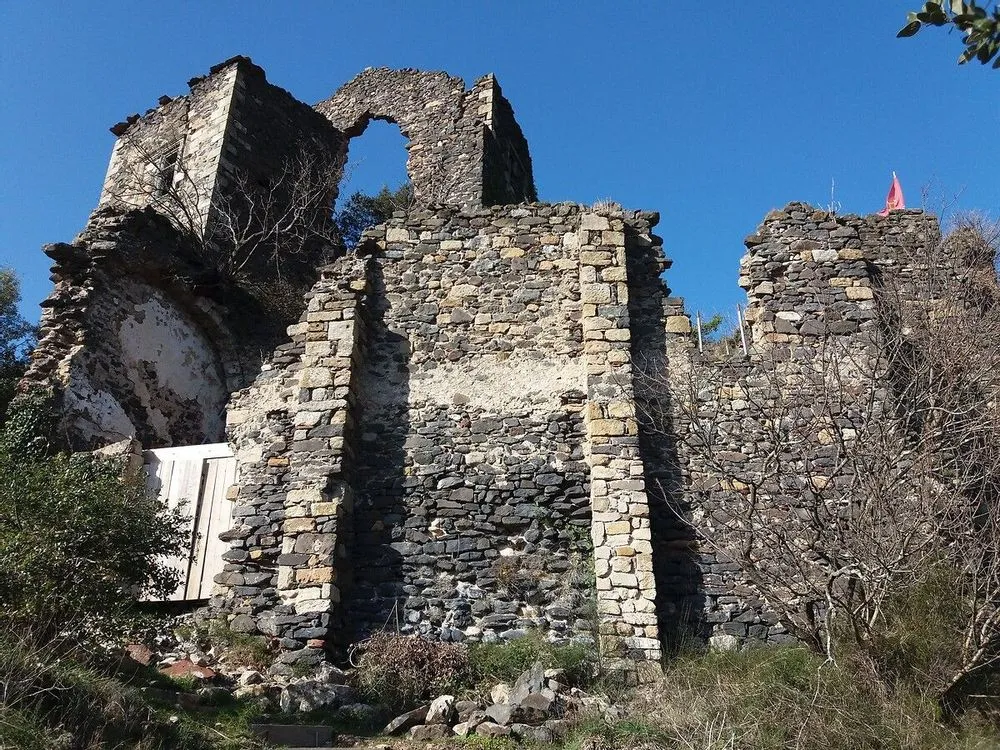 Ruined stone castle walls under a clear blue sky