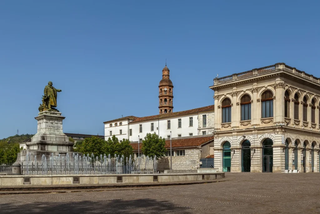 French town square with statue and historic buildings