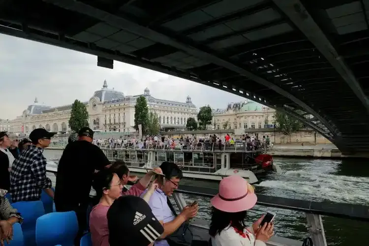Sightseeing boat passing under a Paris bridge