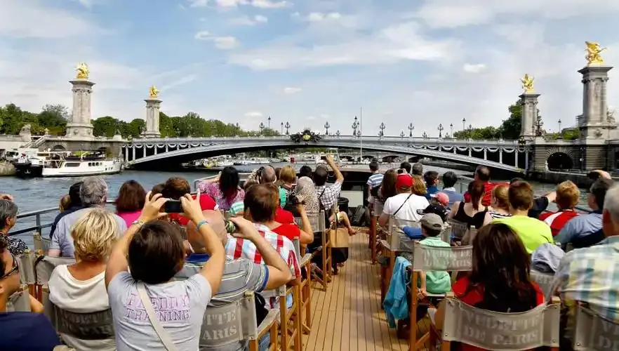 Tourists enjoying a Seine river cruise in Paris