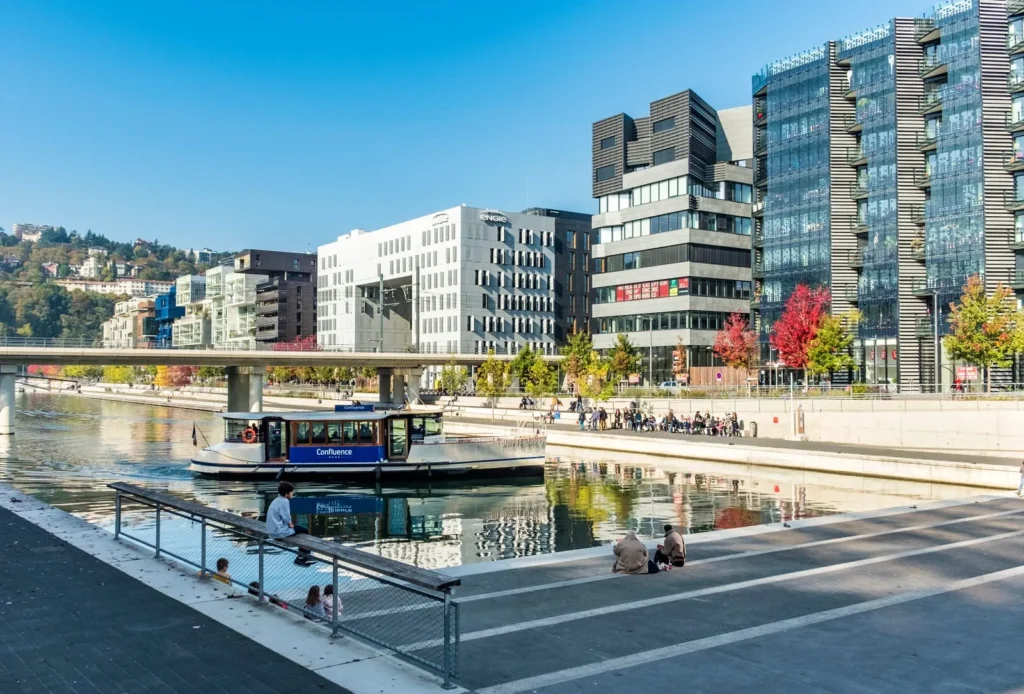 Modern riverside buildings and boat along the Rhône River in Lyon