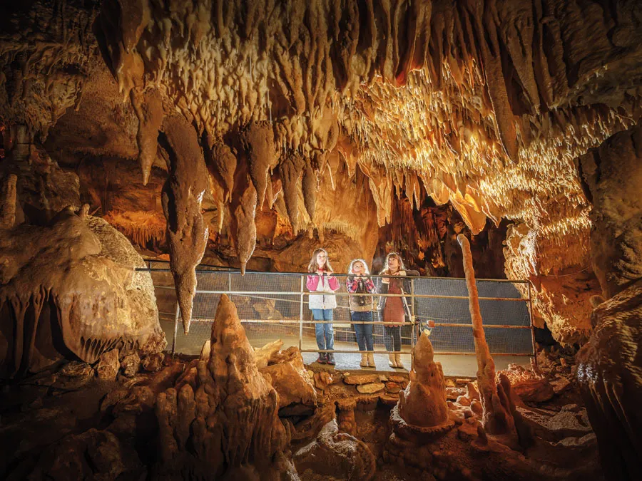 Visitors exploring stalactites inside a Dordogne cave