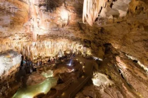 Illuminated stalactites and underground cave walkway