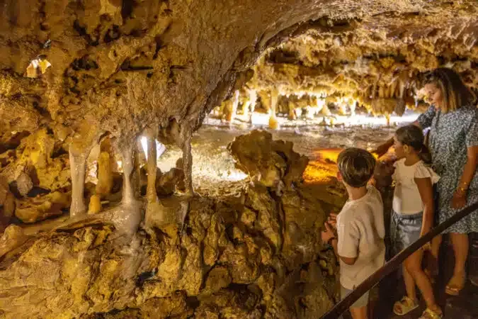Family admiring rock formations inside a French cave